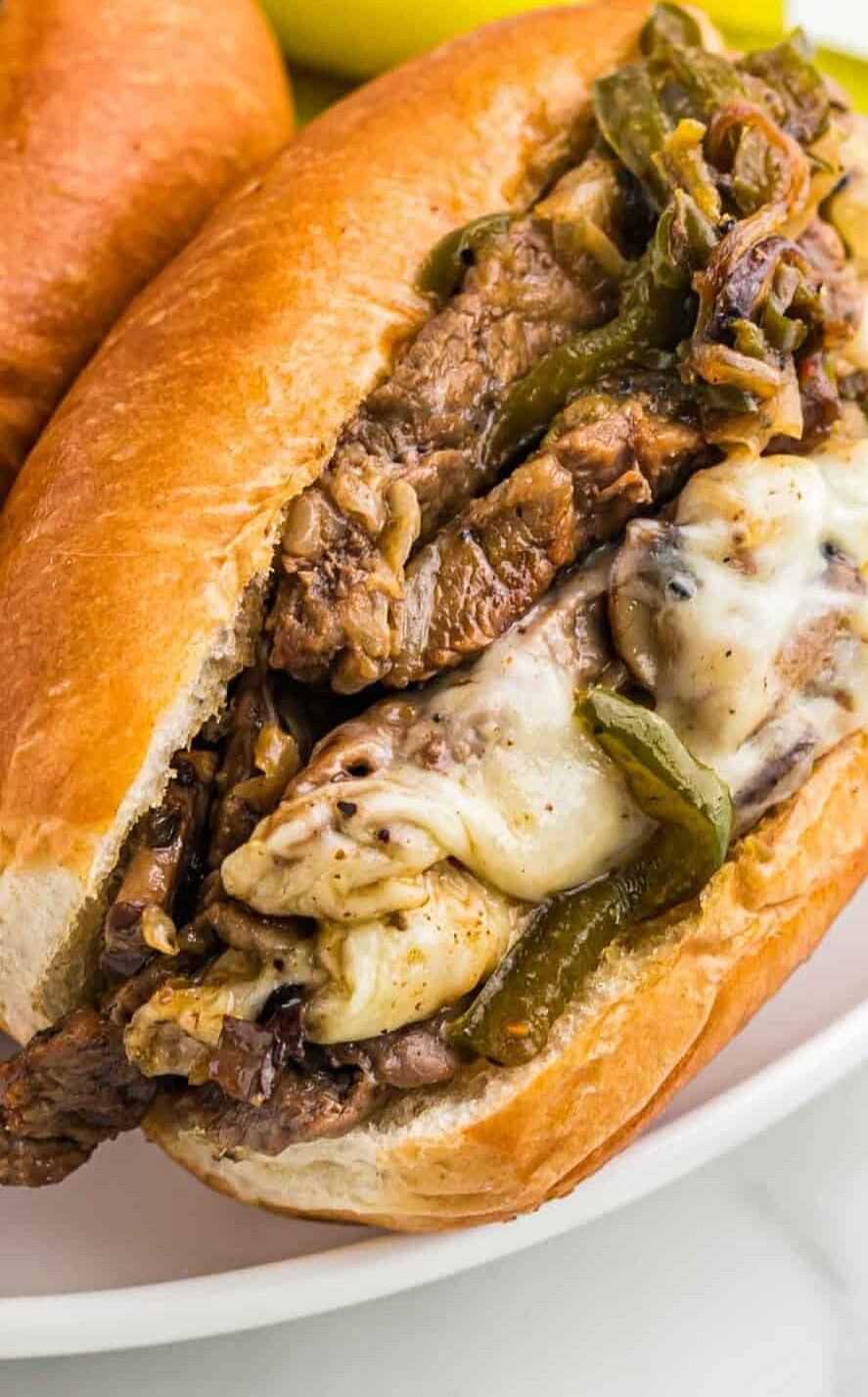 Philly cheesesteak sandwich with melted cheese and peppers.